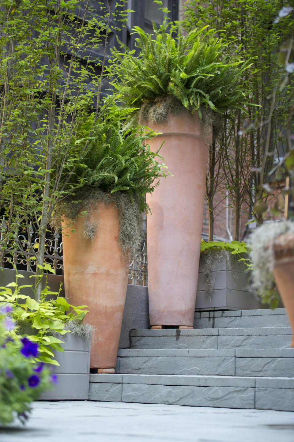 Tall terra cotta planters add a ‘wow’ factor to this stoop, with landscaping design by Janice Parker. Front stoops have long welcomed visitors to city homes, and have served as gathering spots for friends and neighbors engaging in what urban design activist Jane Jacobs called “the sidewalk ballet.” (Neil Landino Jr./Janice Parker Landscape Architects via AP)