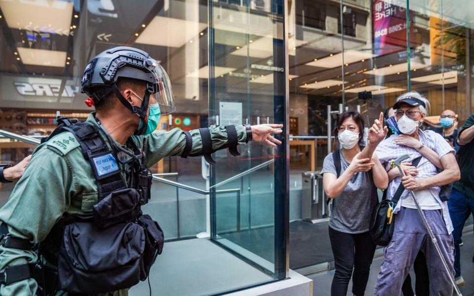 An activist known as Grandpa Wong has an argument with riot police - Bloomberg