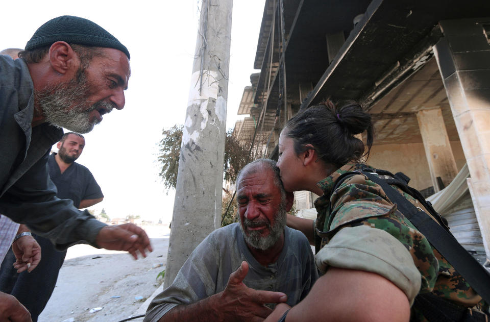 <p>A Syria Democratic Forces (SDF) fighter comforts a civilian who was evacuated with others by the SDF from an Islamic State-controlled neighbourhood of Manbij, in Aleppo Governorate, Syria, Aug. 12, 2016. (REUTERS/Rodi Said) </p>
