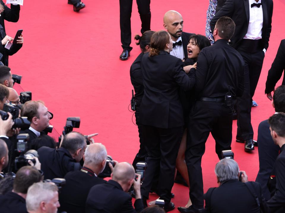 Security remove a protester from the red carpet during the "Three Thousand Years Of Longing" red carpet on May 20, 2022.