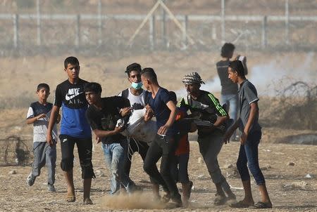 A wounded Palestinian is evacuated during a protest at the Israel-Gaza border in the southern Gaza Strip July 6, 2018. REUTERS/Ibraheem Abu Mustafa