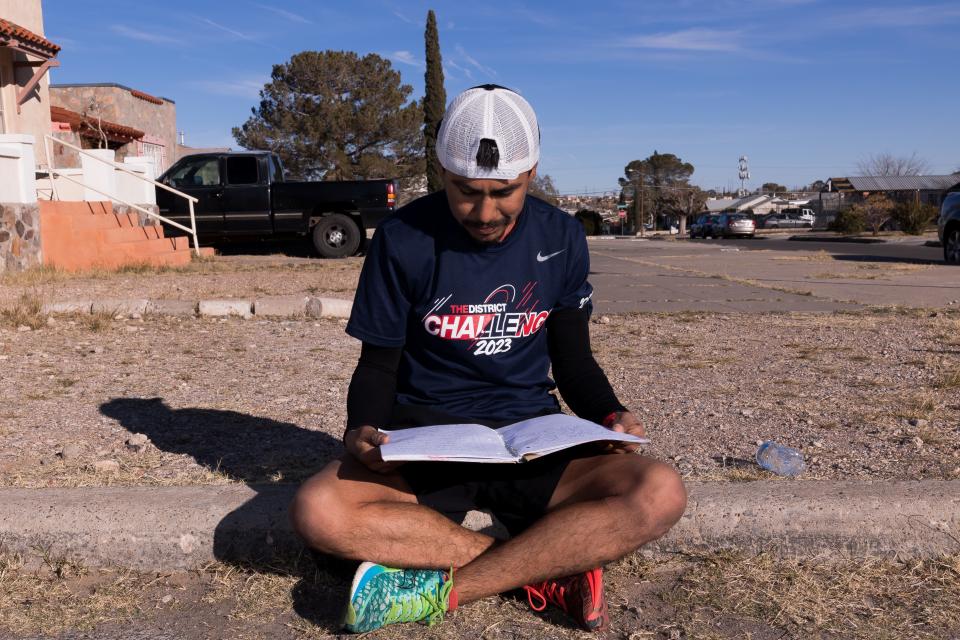 Gonzalo Espinoza, a groundskeeper for Ysleta ISD, reads through his running goal book on the sidewalk in Central El Paso, where he trains for the El Paso Marathon on Friday, Feb. 3, 2023. Espinoza finished in the top 10 in the past two El Paso Marathons.