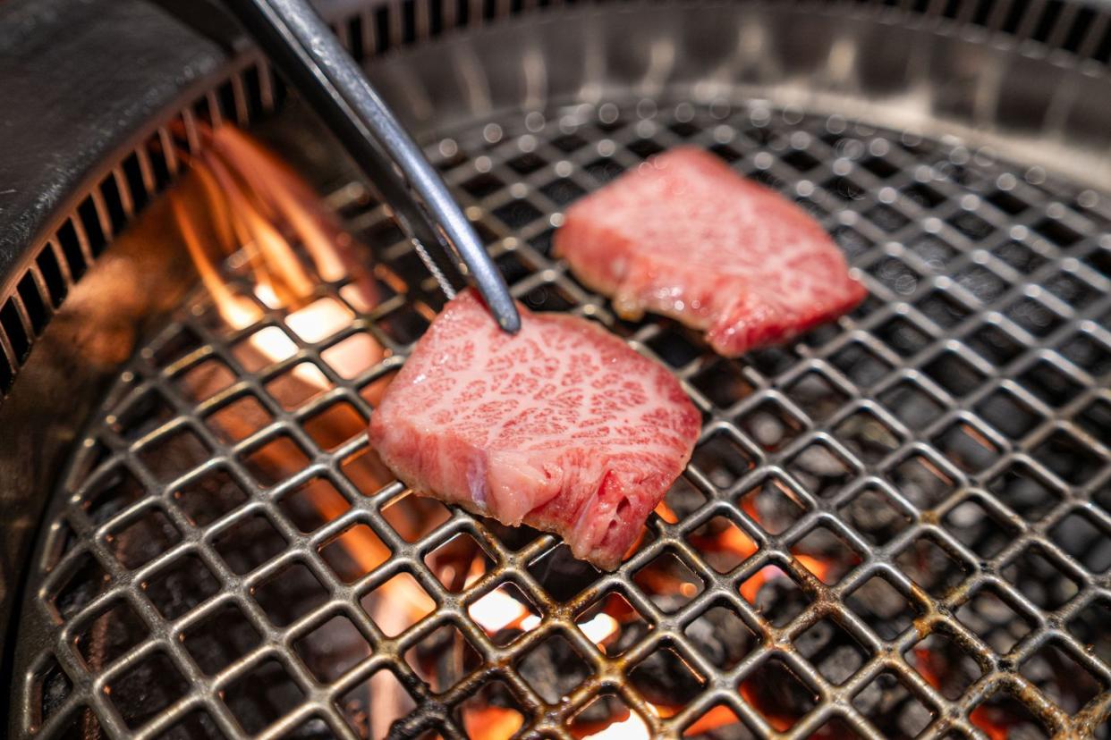 close up of cooking beef on barbecue grill, japanese barbecue