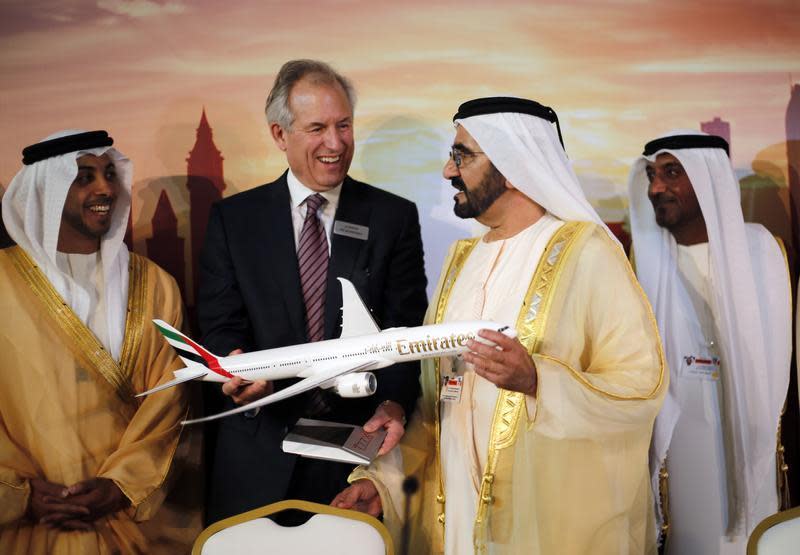 Boeing Chairman James McNerney (2nd L) shows United Arab Emirates' Prime Minister and Ruler of Dubai Sheikh Mohammed bin Rashid al-Maktoum (2nd R) a model of the new version of its 777 long-haul jet during the Dubai Airshow November 17, 2013. REUTERS/Ahmed Jadallah