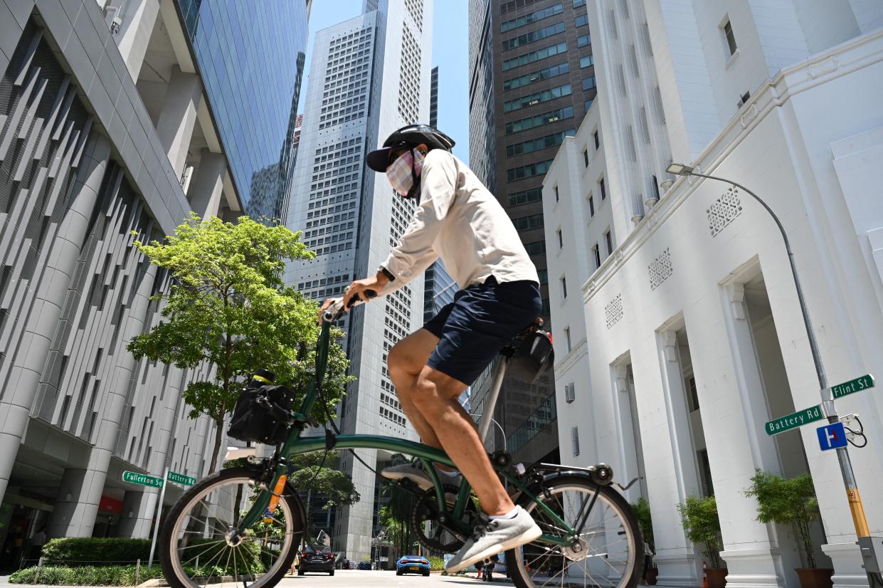 A man seen riding a bicycle at Raffles Place on 20 April. (PHOTO: Getty Images)