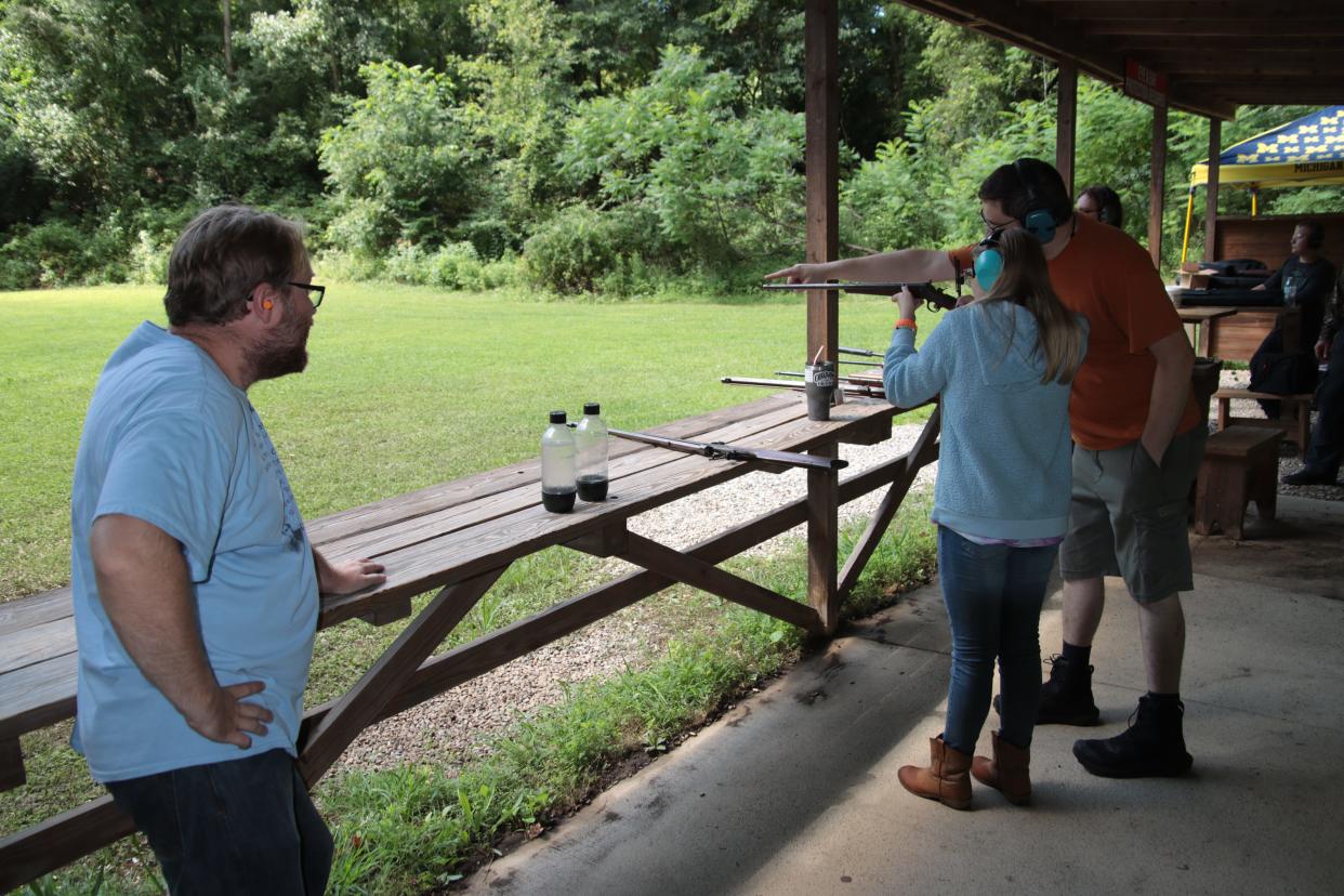 Lenawee County Conservation League range safety officer James Garrison, right, shows Tara Bowe, 12, of Blissfield how to use the sights on a 100-year-old rifle Saturday, Aug. 6, 2022, at the Lenawee County Conservation League. Watching at left is Tara's father, Daryl Bowe.