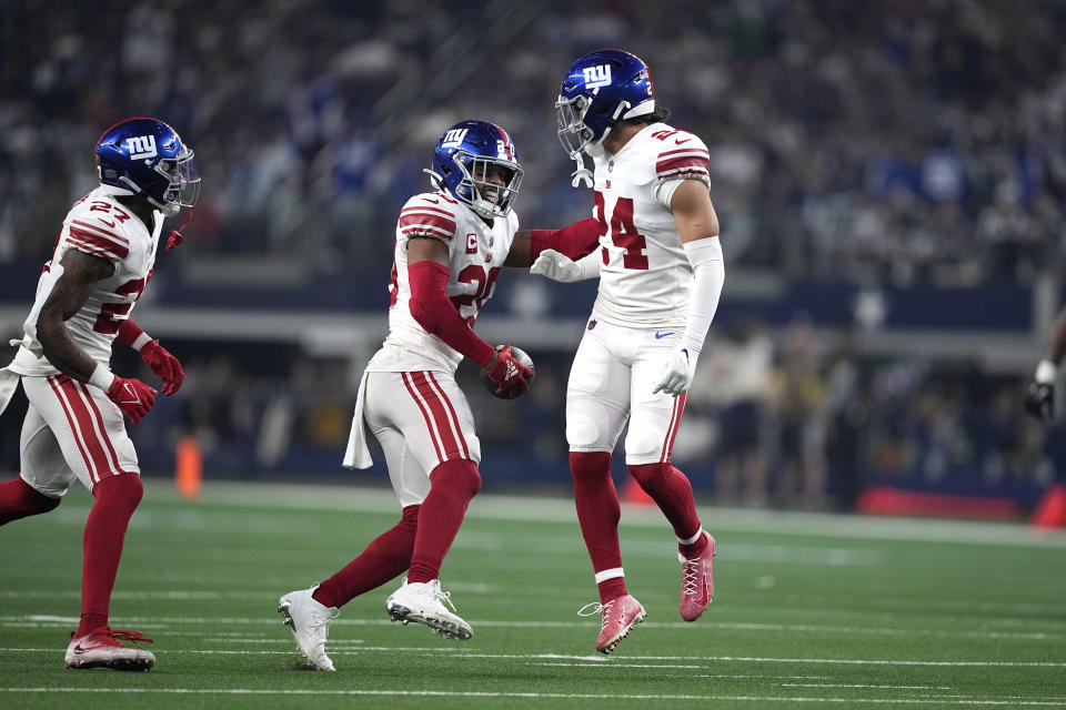 New York Giants safety Julian Love (20) celebrates with Dane Belton (24) after intercepting a pass against the Dallas Cowboys during the first half of an NFL football game Thursday, Nov. 24, 2022, in Arlington, Texas. (AP Photo/Tony Gutierrez)