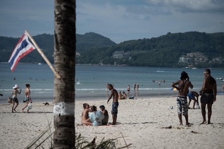 People relax on Patong beach in Phuket, December 4, 2014