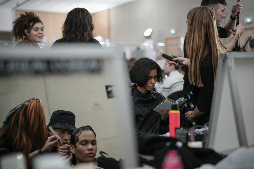 Models are seen preparing backstage before the Elie Saab Haute Couture Spring-Summer 2023 collection presented in Paris, Wednesday, Jan. 25, 2023. (AP Photo/Christophe Ena)