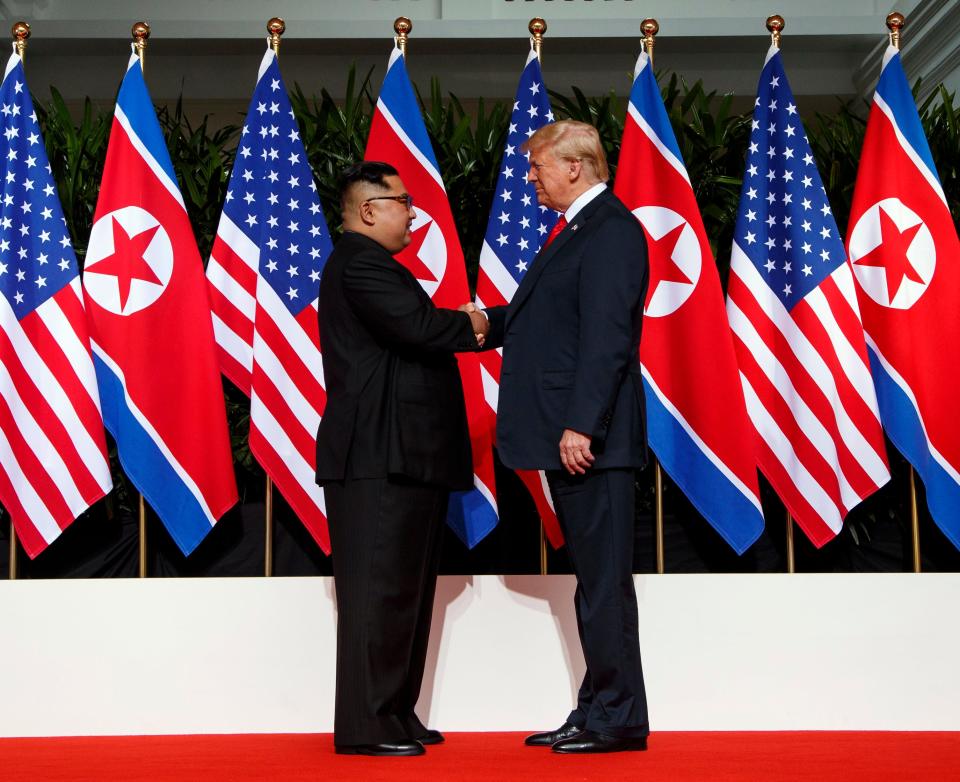 FILE - North Korean leader Kim Jong Un, left, and U.S. President Donald Trump shake hands prior to their meeting on Sentosa Island in Singapore on June 12, 2018. North Korea basked in the global limelight during the last Winter Games in South Korea, with hundreds of athletes, cheerleaders and officials pushing hard to woo their South Korean and U.S. rivals in a now-stalled bid for diplomacy. Four years later, as the 2022 Winter Olympics come to its main ally and neighbor China, North Korea isn't sending any athletes and officials because of coronavirus fears. (AP Photo/Evan Vucci, File)