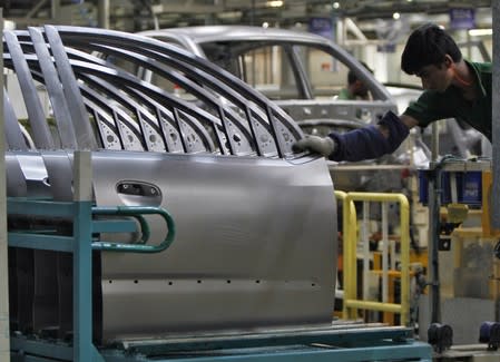 A worker works next to the assembly line of the Hyundai Motor India Ltd. plant at Kancheepuram district in Tamil Nadu