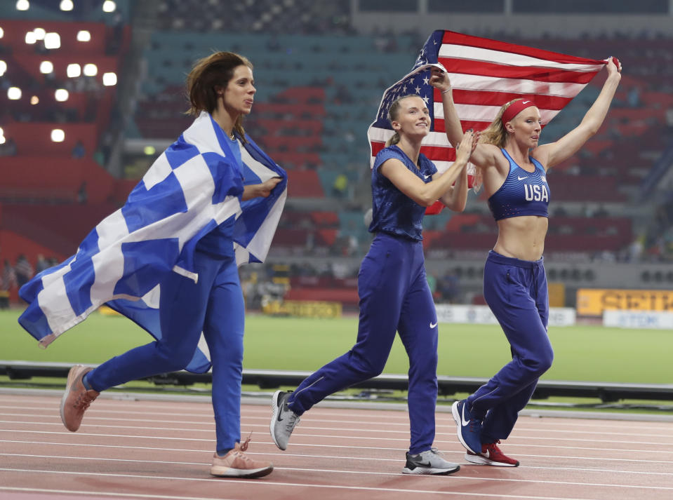 Anzhelika Sidorova, center, competing as a neutral athlete, celebrates with Katerina Stefanidi, left, competing as a neutral athlete; and Sandi Morris, right, of the United States; after the women's pole vault final at the World Athletics Championships in Doha, Qatar, Sunday, Sept. 29, 2019. Sidorova won the gold medal, Morris won the silver and Stefanidi won the bronze. (AP Photo/Hassan Ammar)