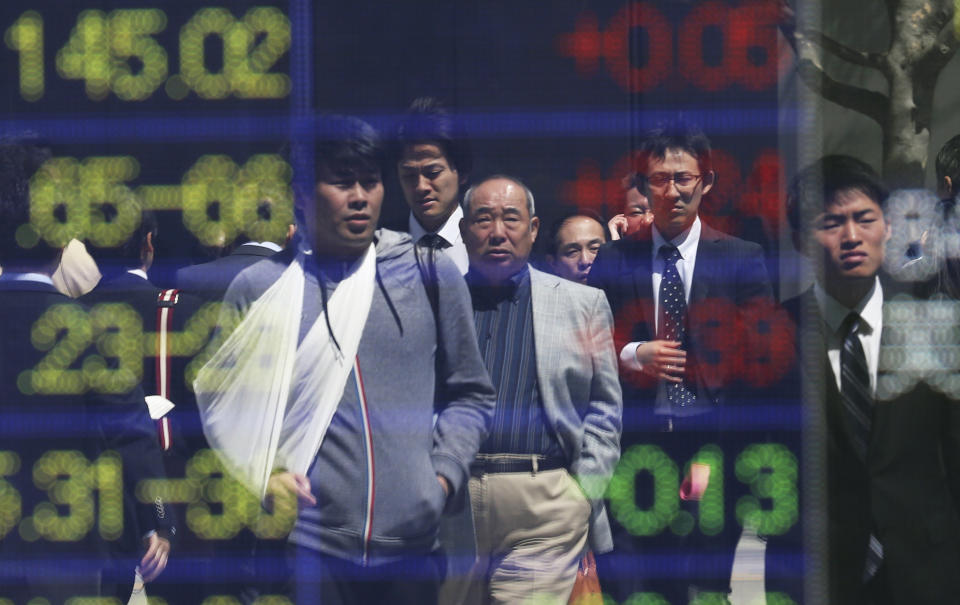 People are reflected on the electronic board of a securities firm in Tokyo, Friday, April 11, 2014. Tokyo's Nikkei 225 stock average fell more than 400 points at one point in morning trading. (AP Photo/Koji Sasahara)