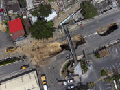 View of a sinkhole on the main road in Villa Nueva, Guatemala, Tuesday, Sept. 27, 2022. Search efforts were underway for a mother and daughter who disappeared when their vehicle was swallowed by a massive sinkhole. (AP Photo/Moises Castillo)