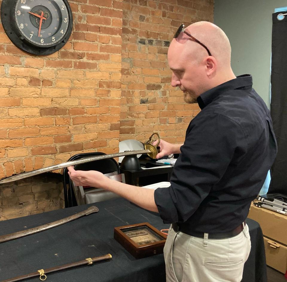 Sherman House Museum Director Michael Johnson examines the sword of Gen. William T. Sherman the museum recently won at a Columbus auction. The museum's winning bid was $130,000.