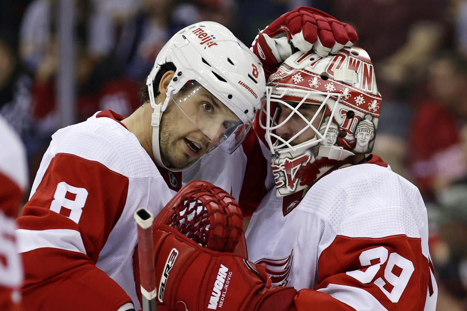 Detroit Red Wings goaltender Alex Nedeljkovic (39) and Ben Chiarot celebrate after the third period of an NHL hockey game against the New Jersey Devils Saturday, Oct. 15, 2022, in Newark, N.J. The Red Wings won 5-2. (AP Photo/Adam Hunger)