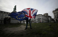 FILE - In this Thursday, Jan. 30, 2020 file photo, a man unfurls a Union and EU flag outside the European Parliament in Brussels. Five years ago, Britons voted in a referendum that was meant to bring certainty to the U.K.’s fraught relationship with its European neigbors. Voters’ decision on June 23, 2016 was narrow but clear: By 52 percent to 48 percent, they chose to leave the European Union. It took over four years to actually make the break. The former partners are still bickering, like many divorced couples, over money and trust. (AP Photo/Virginia Mayo, File)