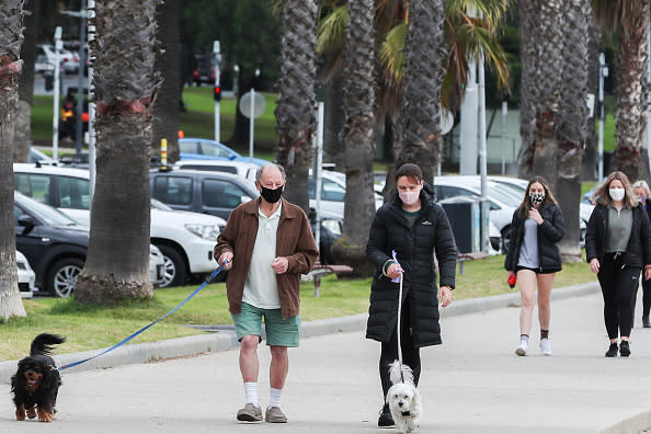 People are seen walking wearing face-masks along the Geelong Waterfront.