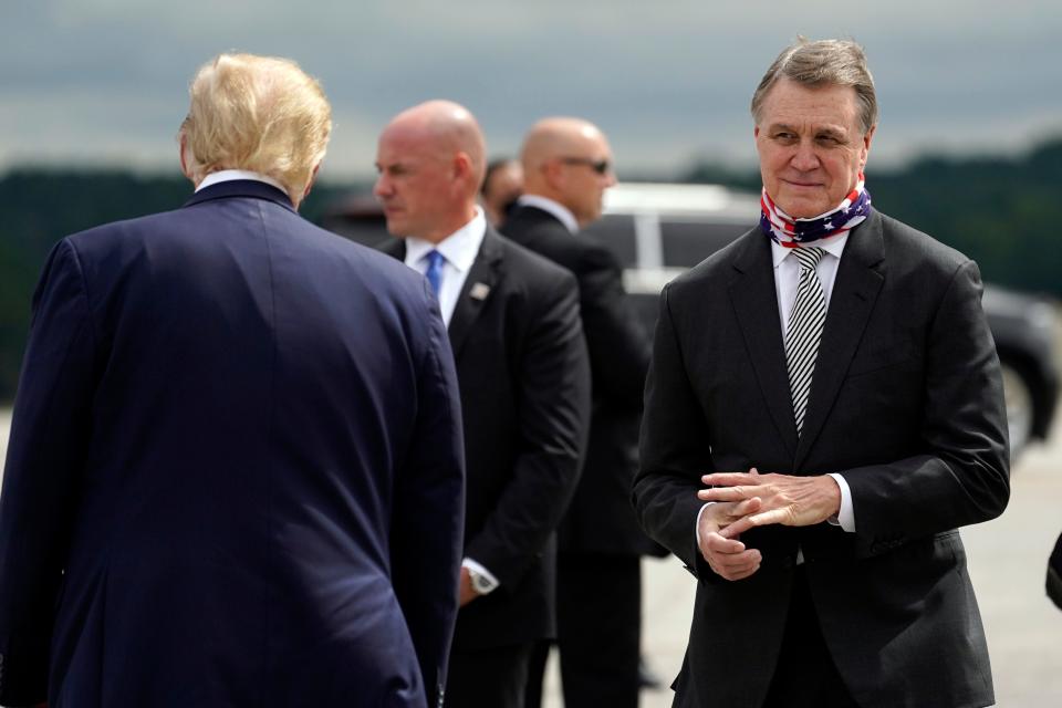 President Donald Trump greets Sen. David Perdue, R-Ga., as he arrives at Dobbins Air Reserve Base for a campaign event at the Cobb Galleria Centre in Atlanta on Sept. 25, 2020.