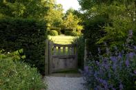 <p> If you&apos;re a fan of traditional styles, then rustic and wooden&#xA0;garden gates&#xA0;can be a stunning solution to divide different &apos;rooms&apos; of your plot.&#xA0; </p> <p> This pretty design is nestled into an evergreen hedge, and helps to frame the open lawn in front. As the experts at&#xA0;Bowles &amp; Wyer&#xA0;say, it&apos;s good to design a space with a vista in mind. </p>