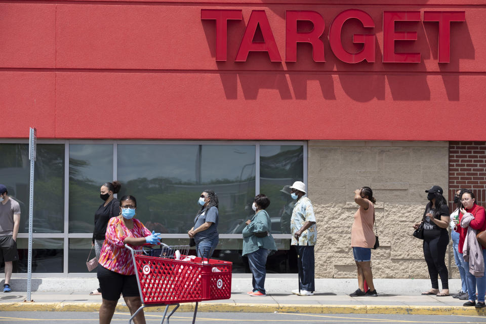 FILE - In this Saturday, May 30, 2020, file photo, people in protective masks line up to enter a Target, in Boston, amid the coronavirus pandemic. (AP Photo/Michael Dwyer, File)