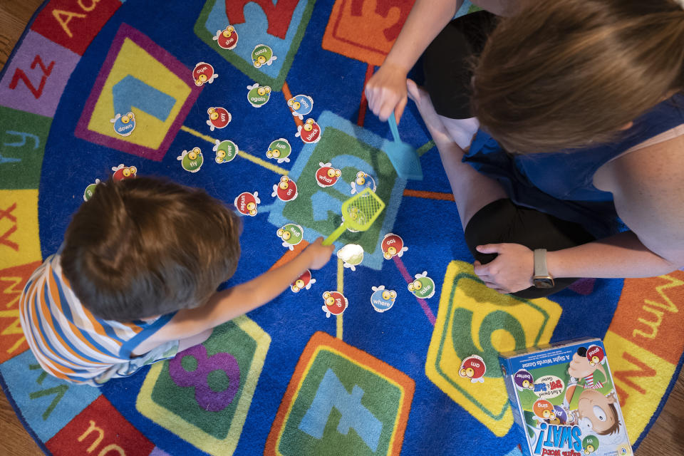 Logan Strauss, 5, sits on the floor with his mother Karen while they play a word game in Basking Ridge, N.J., Wednesday, July 28, 2021. Logan's parents are keeping him out of school until he gets the COVID-19 vaccine. (AP Photo/Mark Lennihan)