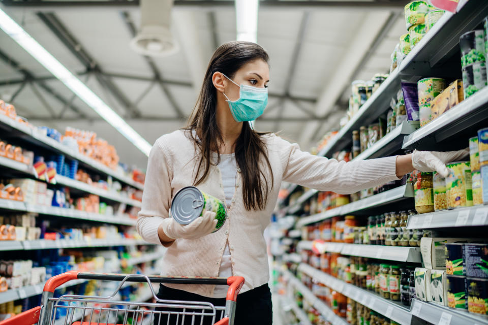 Woman preparing for pathogen virus pandemic spread quarantine.Choosing nonperishable food essentials.Budget buying at a supply store.Pandemic quarantine preparation.Emergency to buy list