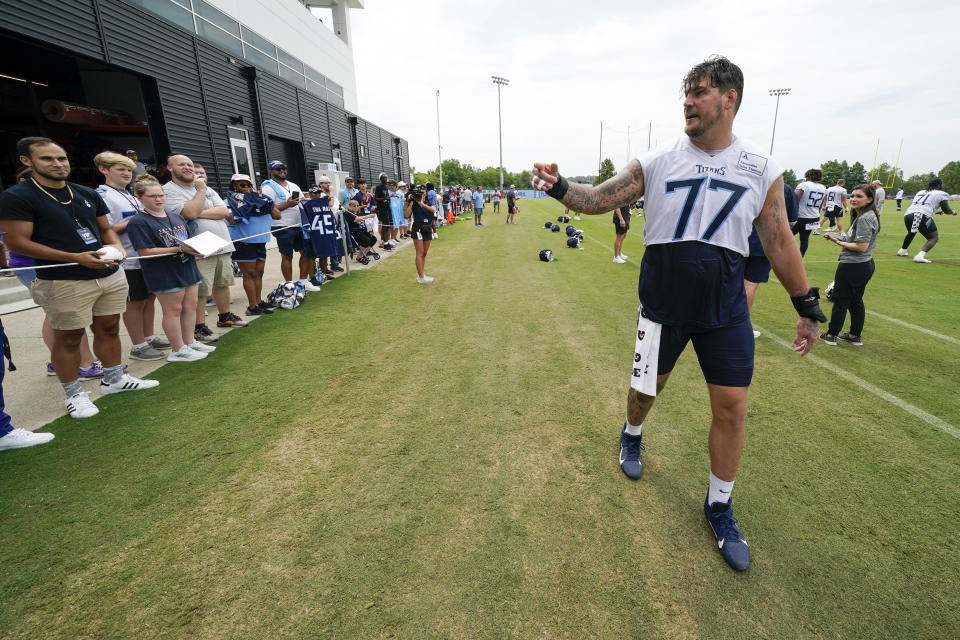 Tennessee Titans tackle Taylor Lewan (77) talks to fans after a training camp practice at the NFL football team's facility Saturday, July 30, 2022, in Nashville, Tenn. (AP Photo/Mark Humphrey)