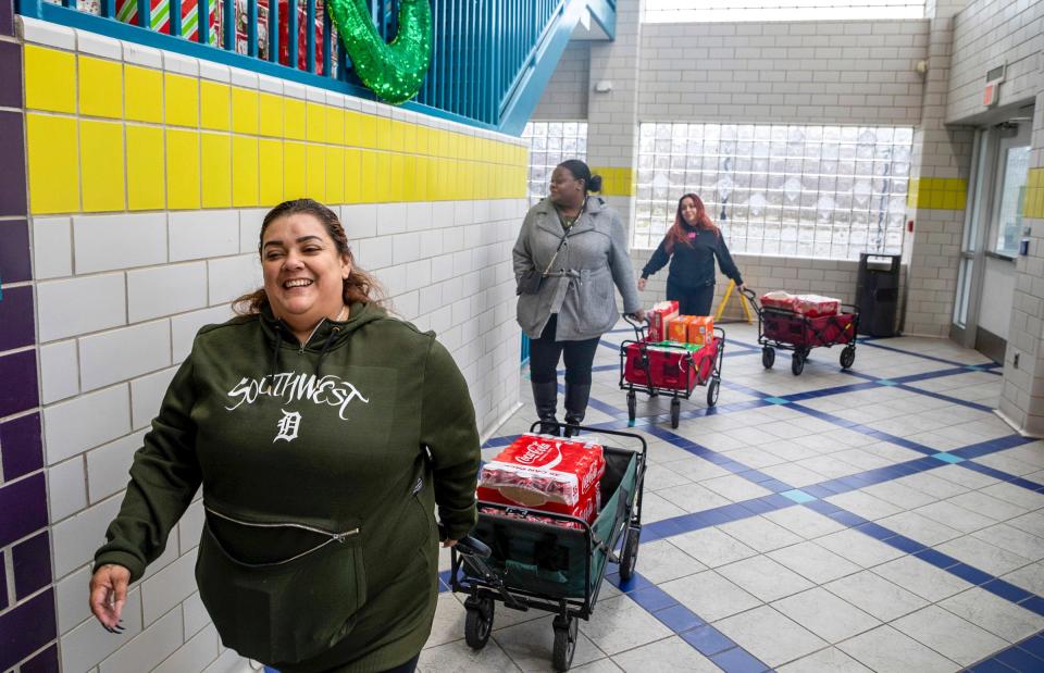 Lisa Gonzalez, left, Chenika Rogers, middle, and Nora Rodriguez deliver items to the Patton Recreation Center ahead of the Holiday Festival on behalf of the Congress of Communities and Detroit Champions for Hope in Detroit on Wednesday, Dec. 7, 2022. 