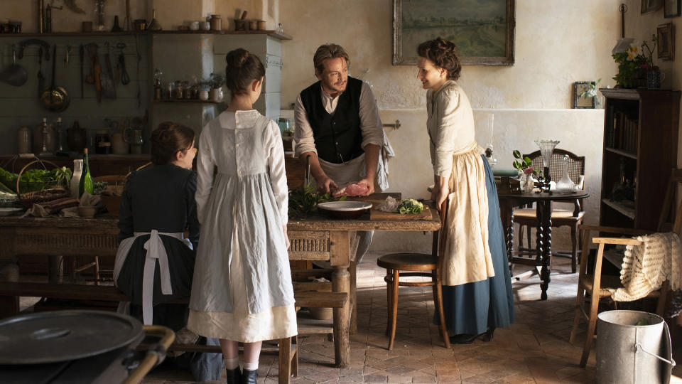 This image released by IFC Films shows Juliette Binoche, right, and Benoît Magimel, center, in a scene from "The Taste of Things." (Stéphanie Branchu/IFC Films via AP)