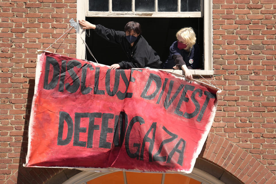 FILE - Activists hang a placard from a window of an upper floor of a building at Rhode Island School of Design, Tuesday, May 7, 2024, in Providence, R.I., as students and supporters, who have taken over a portion of the building, are demanding that the school condemn Israel's war effort in Gaza, and that the school divest from investments that benefit Israel. (AP Photo/Steven Senne, File)