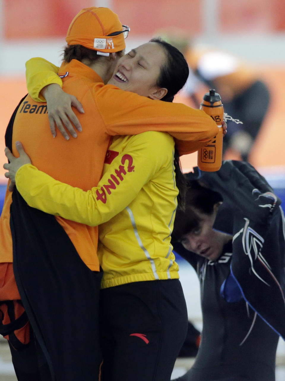 Bronze medallist Margot Boer of the Netherlands, left, hugs gold medallist China's Zang Hong, center, as Heather Richardson of the U.S., right, watches after the women's 1,000-meter speedskating race at the Adler Arena Skating Center during the 2014 Winter Olympics in Sochi, Russia, Thursday, Feb. 13, 2014. (AP Photo/Matt Dunham)