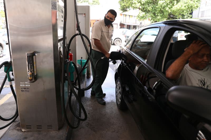 A worker pumps a car with gasoline at a gas station in Rio de Janeiro