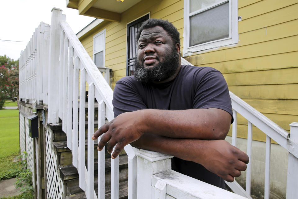 Shaun Mills, who is currently furloughed from his job due to COVID-19, stands in front of his home in New Orleans, Wednesday, Aug. 26, 2020. Even before he lost his line-cook job, he said, he struggled. “The prices of your rent, the prices of the insurance, the living expenses, the food expenses. Everything goes up year after year except for the pay," he said. “How can you expect a grown person to be able to provide for his family?” (AP Photo/Rusty Costanza)