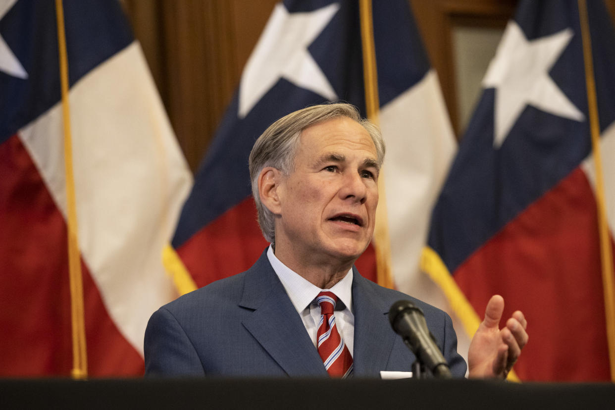 Greg Abbott speaks into a microphone