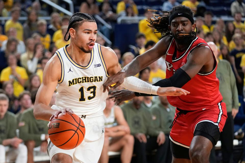 Michigan forward Olivier Nkamhoua (13) drives on Youngstown State forward Ziggy Reid (1) in the second half at Crisler Center in Ann Arbor on Friday, Nov. 10, 2023.