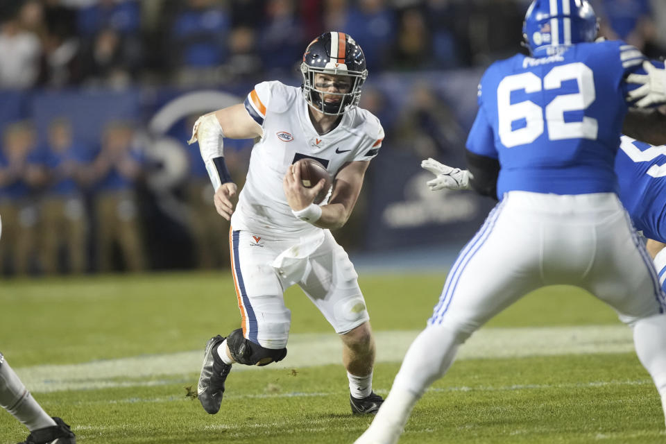 Virginia quarterback Brennan Armstrong (5) scrambles as BYU defensive lineman Atunaisa Mahe (62) is blocked during the first half of an NCAA college football game Saturday, Oct. 30, 2021, in Provo, Utah. (AP Photo/George Frey)