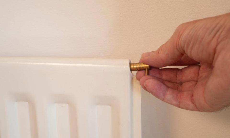 Hand bleeding a radiator to make the heating more efficient.