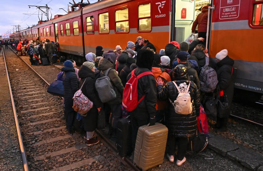 Ukrainian refugees board a train to Krakow after crossing the border in Medyka, Poland