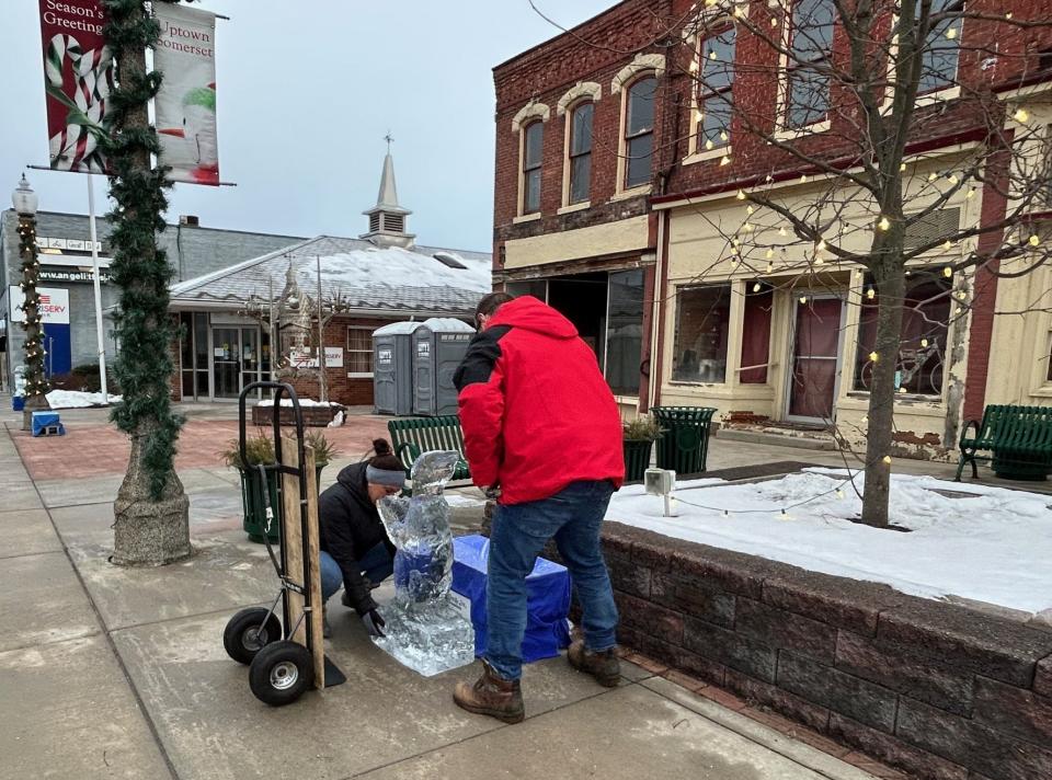 Volunteers Heather Ream, her first time, and Luke Boland, his fifth time, set up one of the ice sculptures unloaded Friday morning for the annual Fire & Ice- Festival taking place this weekend.