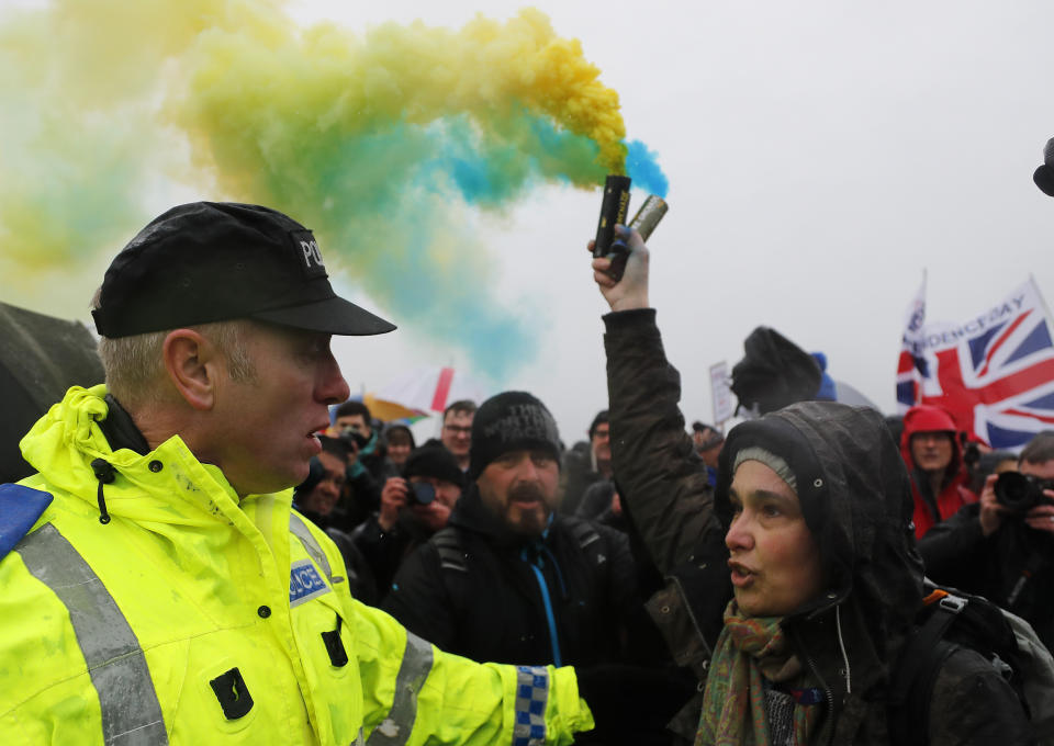 A pro European Union demonstrator releases flares to protest the start of the first leg of March to Leave the European Union, in Sunderland, England, Saturday, March 16, 2019. Hard-core Brexiteers led by former U.K. Independence Party leader Nigel Farage are setting out on a two-week "Leave Means Leave" march between northern England and London, accusing politicians of "betraying the will of the people." (AP Photo/Frank Augstein)