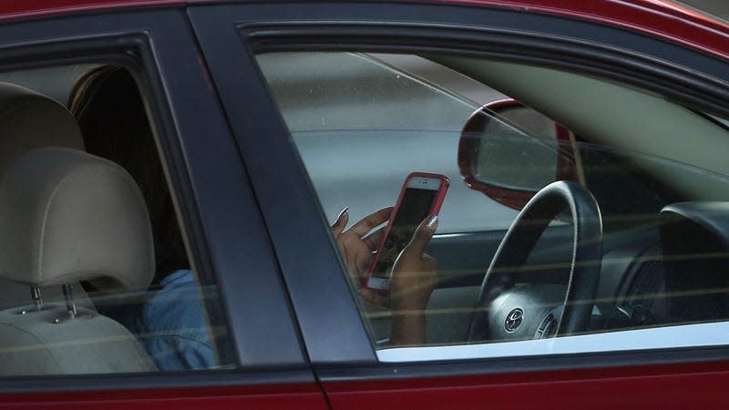 A driver using their phone while driving