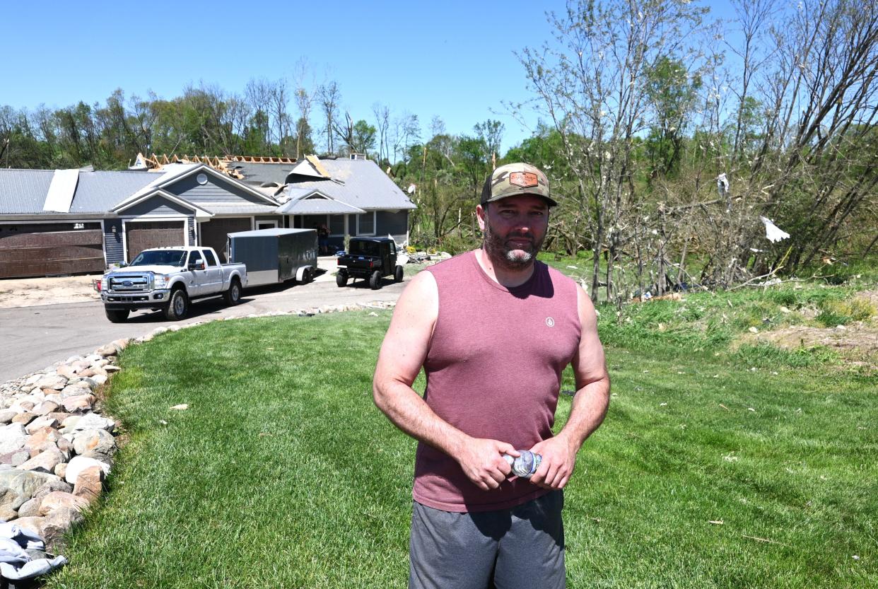 Jason Kohn stands in front of his Ralston Road home where he received the tornado alert. He made it to the basement before the twister took off the back of his home.