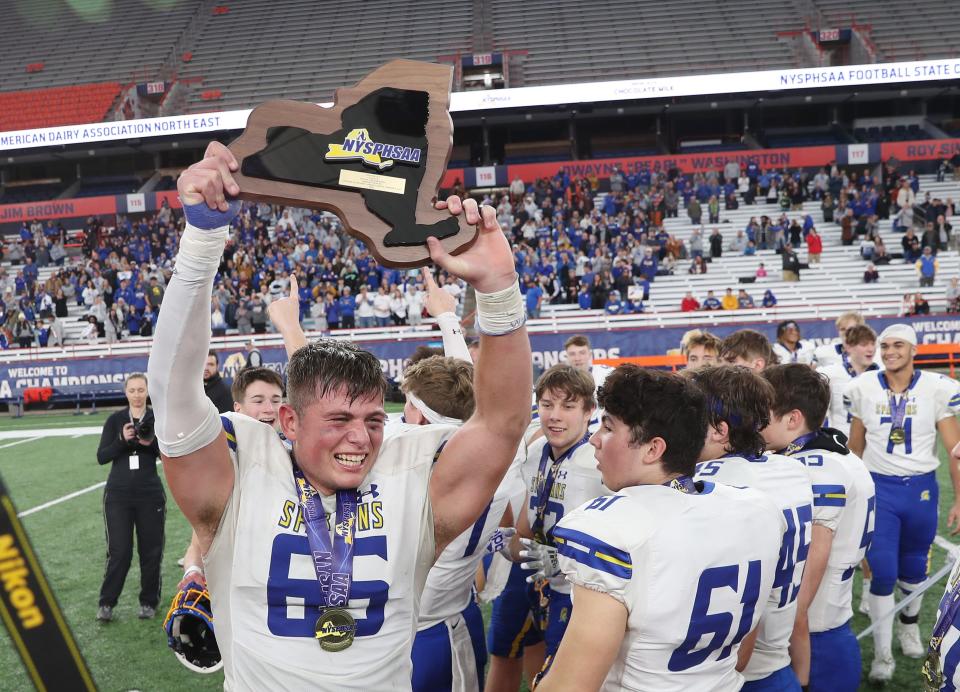 Maine-Endwell's Adam DeSantis (65) and his teammates celebrate their victory over Pleasantville in the state Class B football championship at JMA Wireless Dome in Syracuse Dec. 4, 2022.