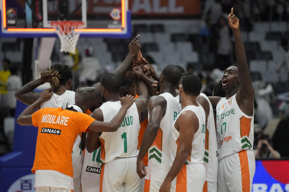 Team Cote d'Ivoire celebrates after defeating Iran during their Basketball World Cup group G match at the Indonesia Arena stadium in Jakarta, Indonesia, Monday, Aug. 28, 2023. (AP Photo/Dita Alangkara)