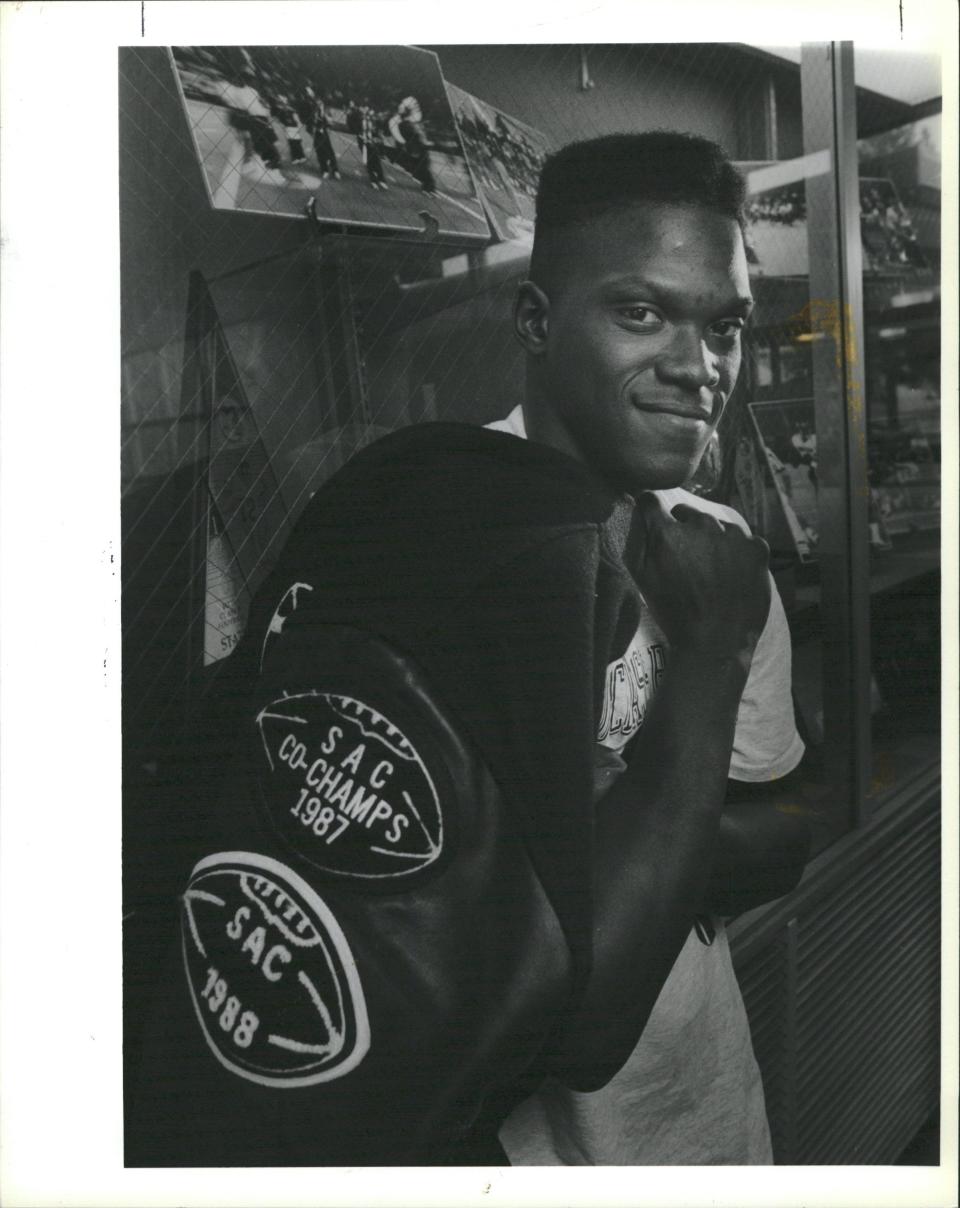 Dearborn Heights Robichaud three-sport athlete Tyrone Wheatley in front of the school's trophy case.