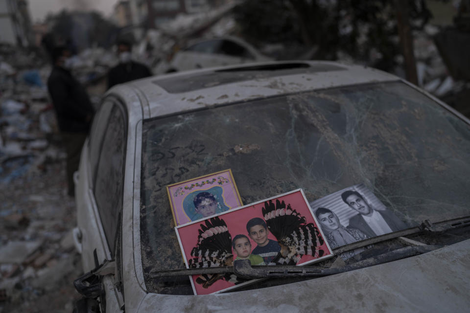 Pictures recovered from the rubble of a building destroyed during the earthquake are placed in a windshield of a car in Antakya, southeastern Turkey, Sunday, Feb. 12, 2023. Turkish justice officials are targeting contractors allegedly involved in shoddy and illegal construction after a pair of earthquakes on Feb. 6 collapsed thousands of buildings in southeast Turkey and northern Syria. (AP Photo/Bernat Armangue)