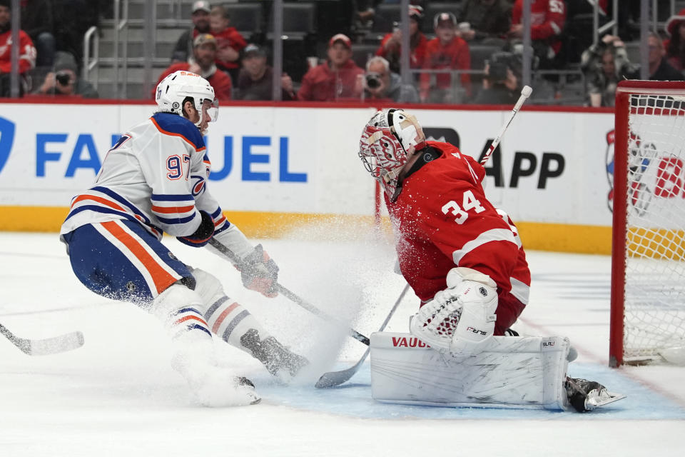 Edmonton Oilers center Connor McDavid (97) scores on Detroit Red Wings goaltender Alex Lyon (34) in the third period of an NHL hockey game Thursday, Jan. 11, 2024, in Detroit. (AP Photo/Paul Sancya)