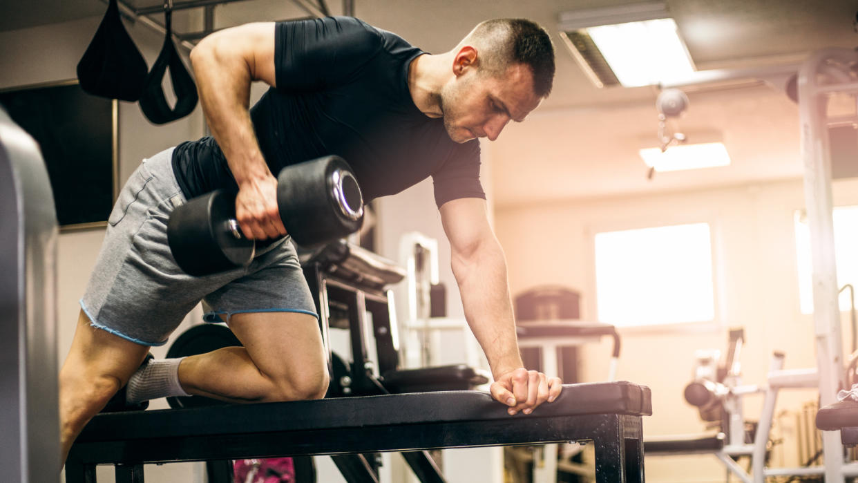  Man doing a dumbbell arm workout at the gym 