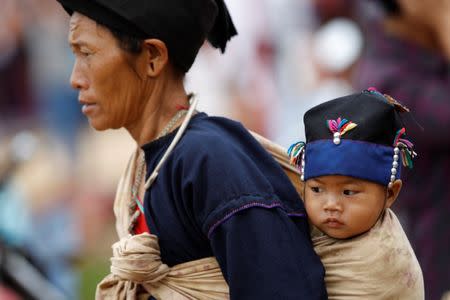 A woman carries her baby in a village outside Pansang, Wa territory in northeast Myanmar October 3, 2016. REUTERS/Soe Zeya Tun